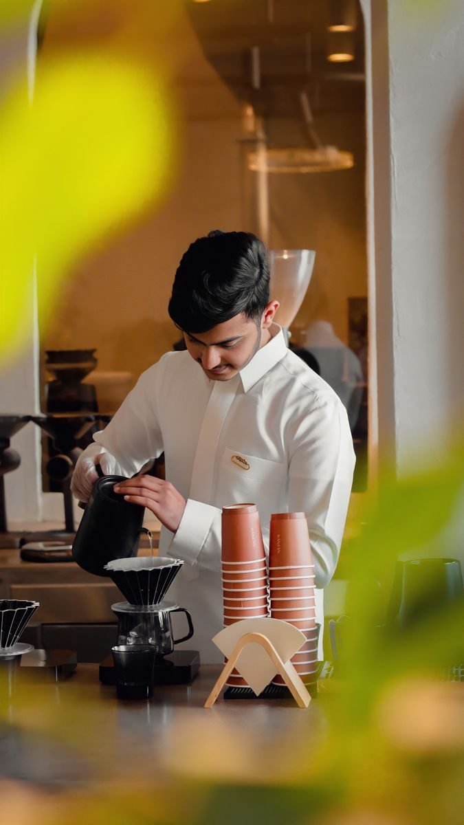 Barista sirviendo café de método filtrado