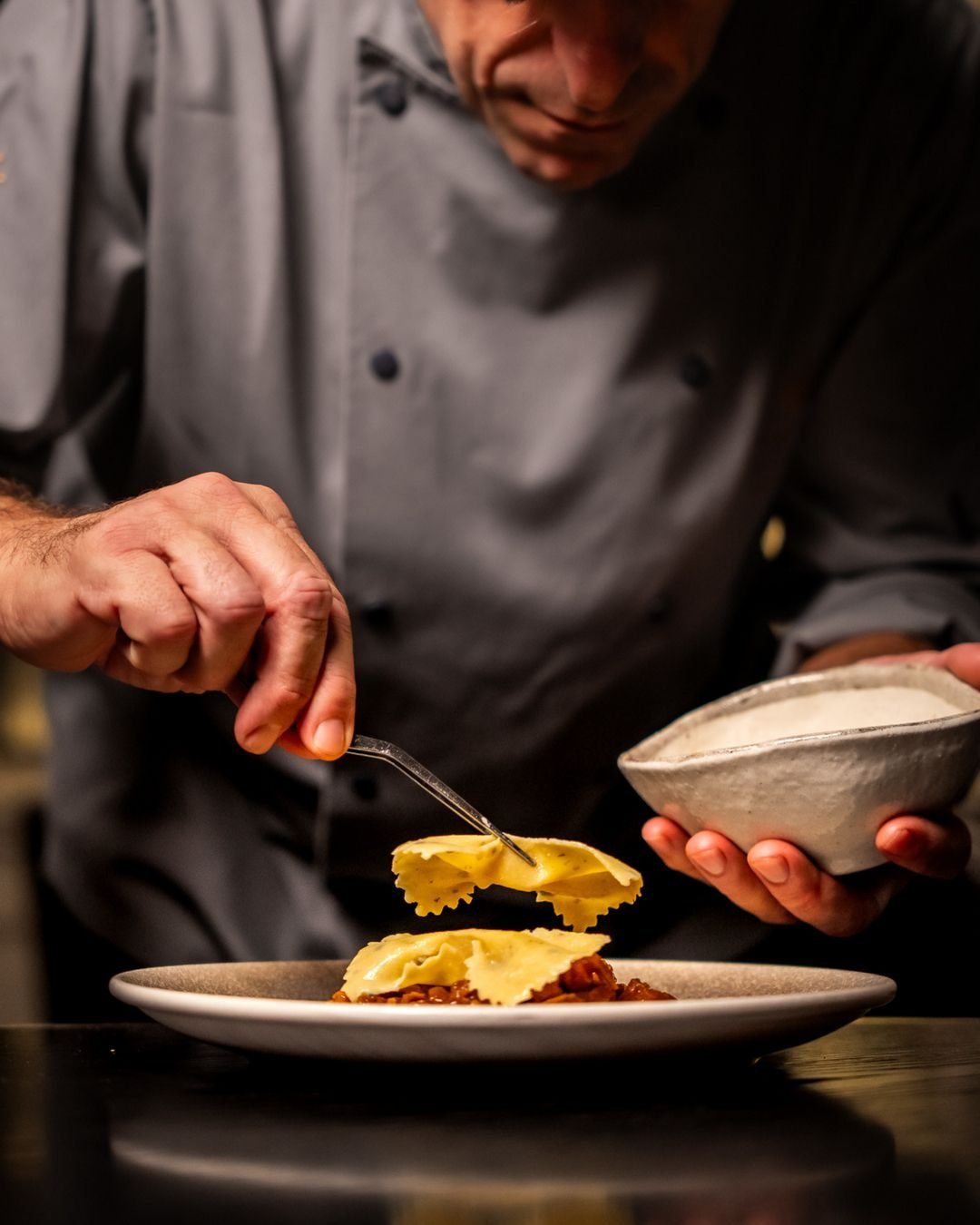 Chef emplatando ravioles con precisión