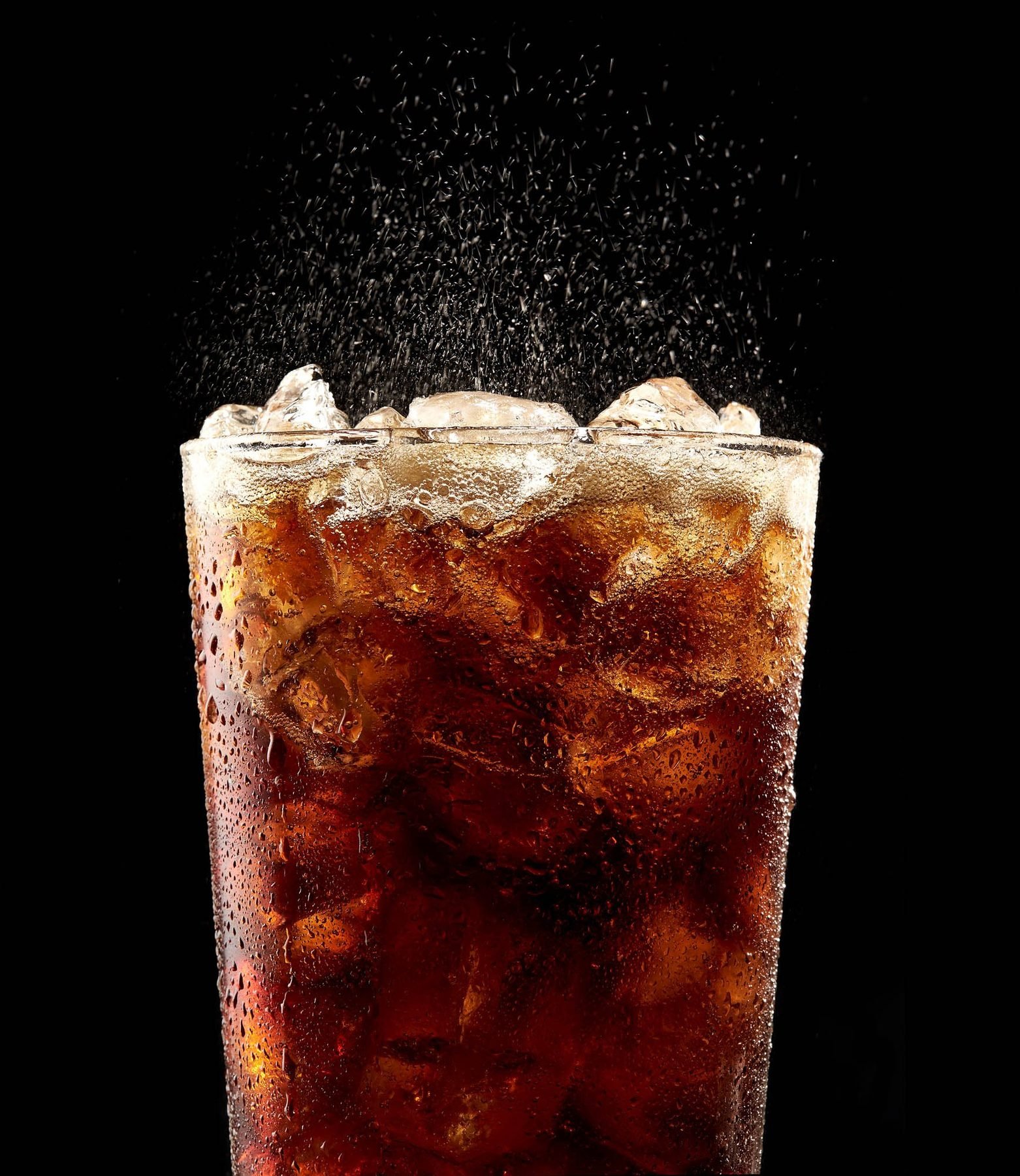 Refresco de cola con hielo y gas en movimiento