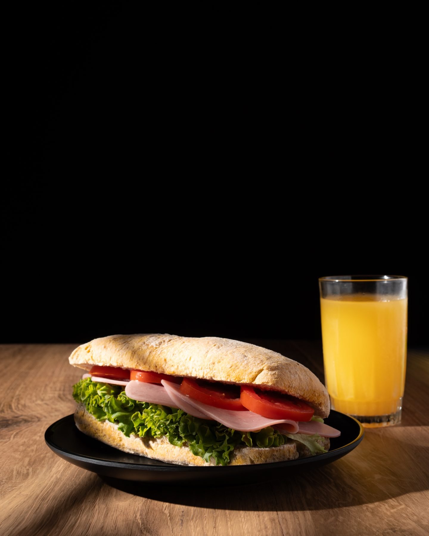 Sándwich de jamón y vegetales con jugo de naranja